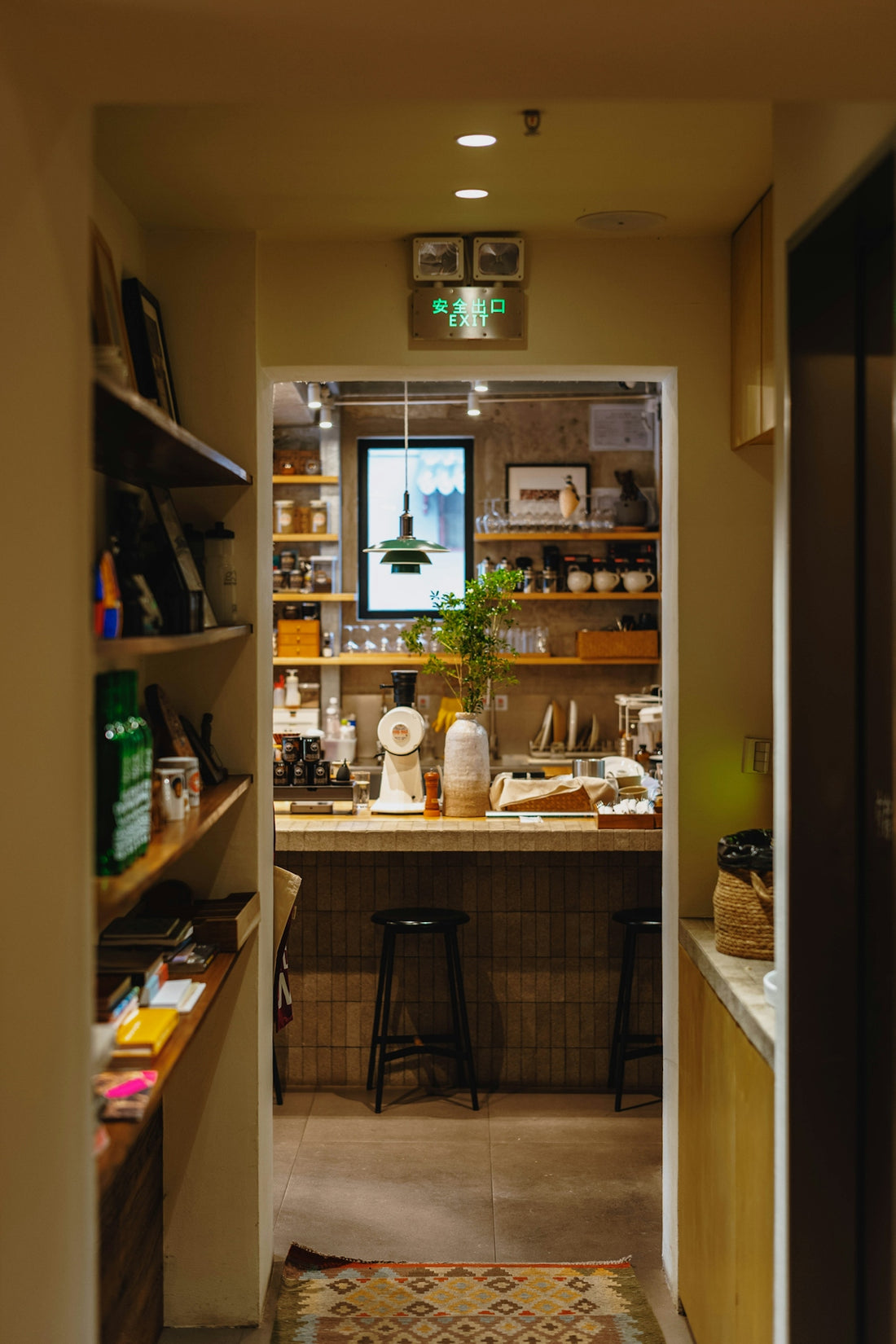 A cozy cafe interior with a counter, stools, and shelves