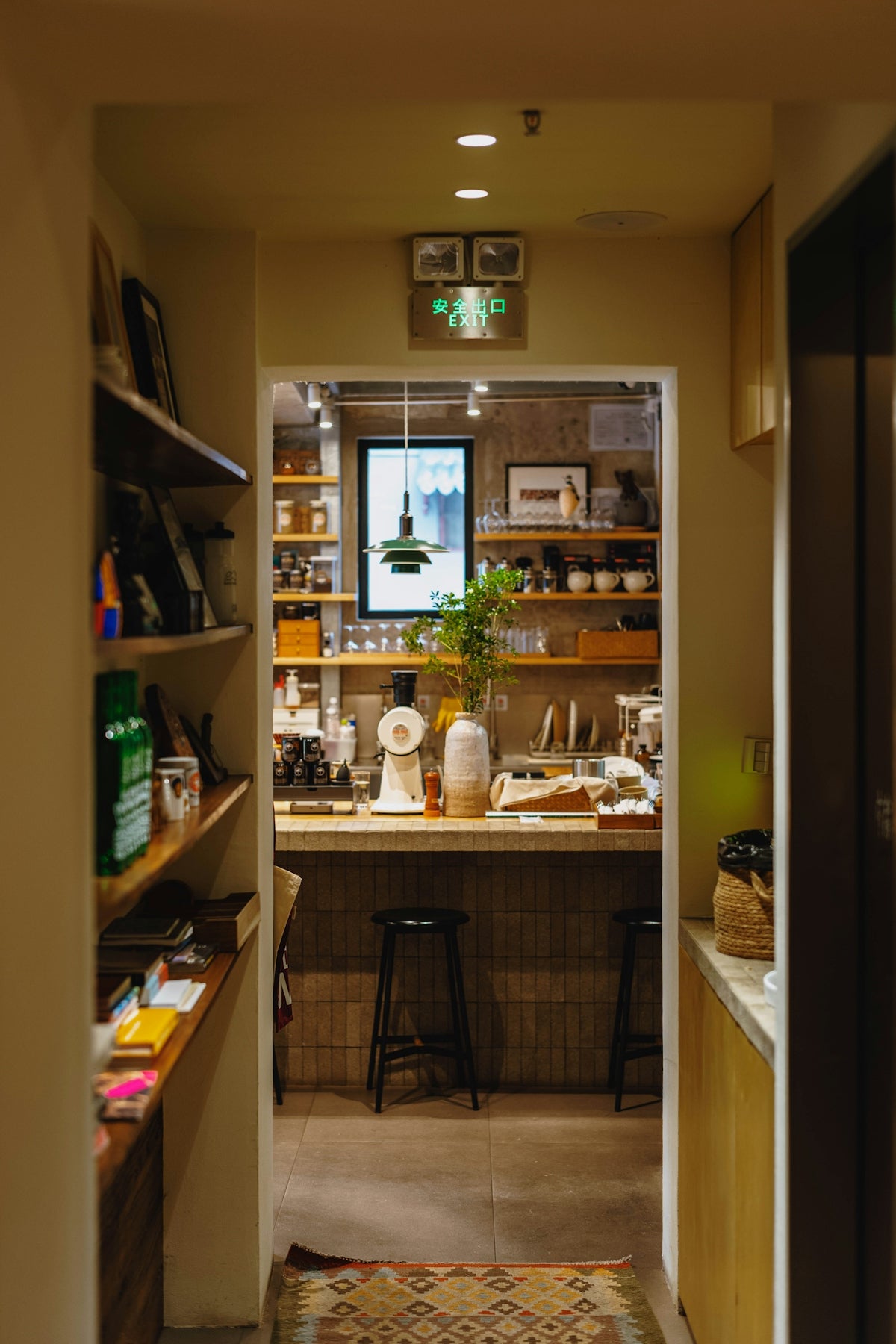 A cozy cafe interior with a counter, stools, and shelves